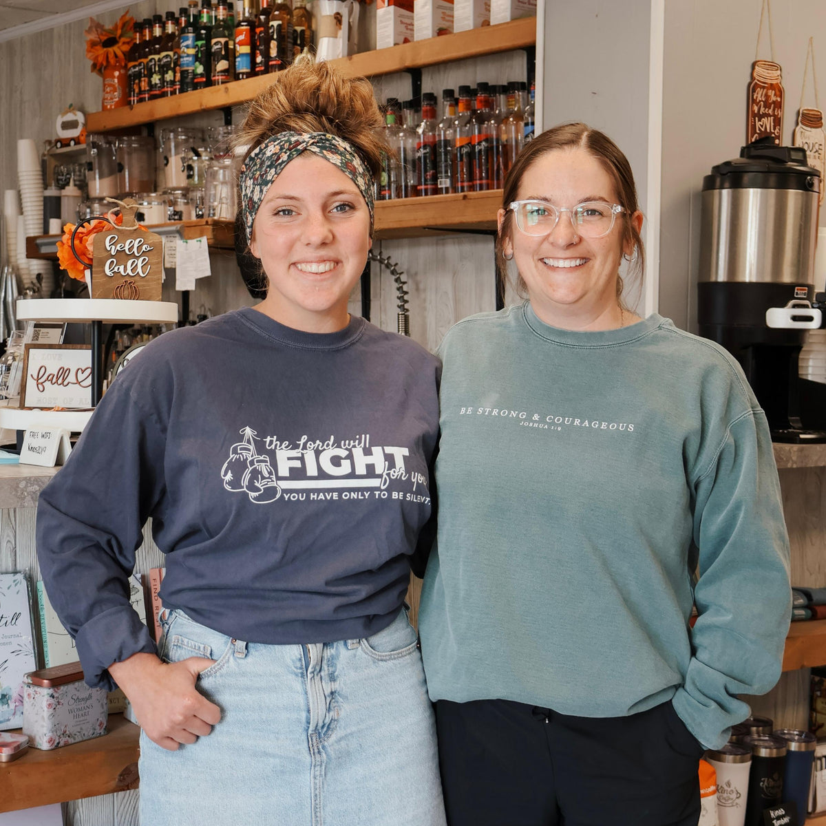 Two women standing in a store with shelves of products in the background